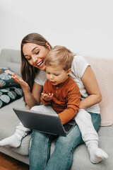happy mother with her little son enjoying in online video chat or communication with family members 