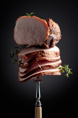 Wall Mural - Sliced smoked gammon with thyme branches on a fork.