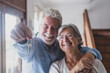 © Daniel - Happy senior old aged woman and man customer landlord hold key to new house apartment give to camera, older retired couple of seniors hand real estate owner make sale purchase property deal concept