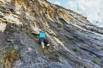 Climber climbs on the rock wall. Climbing gear. Climbing equipment.