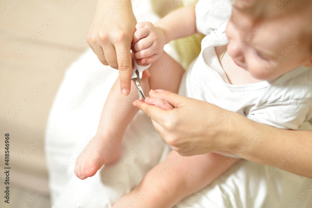 selective focus The mother cuts the child's toenails on the arm with baby safe scissors. Close-up. Self care authentic concept. Mother care is most important for baby healthy life lifestyle