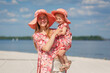 © Kate - A charming girl in a light summer sundress walks on the sandy beach with her little daughter. Enjoys warm sunny summer days