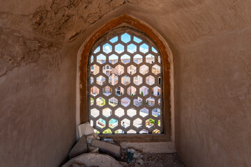 Wooden window with hexagonal latice leading to a bazaar crossroads in Kerman, Iran.