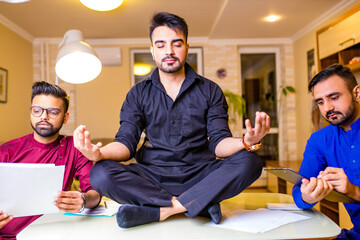 indian people doing yoga in office at night time deadline concept