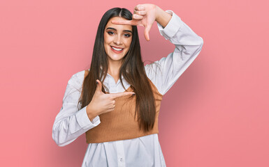 Wall Mural - Young beautiful woman wearing casual white shirt smiling making frame with hands and fingers with happy face. creativity and photography concept.