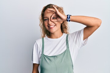 Wall Mural - Beautiful caucasian woman wearing casual clothes smiling happy doing ok sign with hand on eye looking through fingers