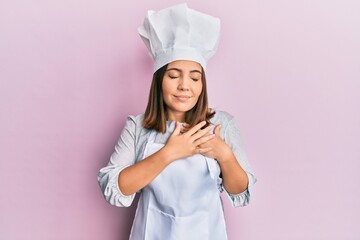 Poster - Young beautiful woman wearing professional cook uniform and hat smiling with hands on chest with closed eyes and grateful gesture on face. health concept.