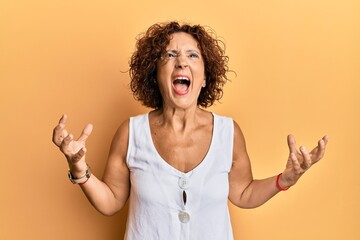 Sticker - Beautiful middle age mature woman wearing casual clothes crazy and mad shouting and yelling with aggressive expression and arms raised. frustration concept.