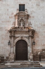 puerta de entrada a la iglesia del convento de santa clara también llamado Real Monasterio de la Encarnación flanqueada por columnas y faroles con una escultura encima. Almería (España)