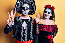 Young Couple Wearing Mexican Day Of The Dead Costume Over Yellow Showing And Pointing Up With Fingers Number Nine While Smiling Confident And Happy.