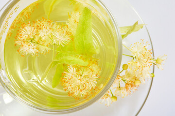 Transparent glass cup of tea with linden isolated on white