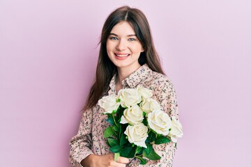 Sticker - Young beautiful caucasian girl holding bouquet of white flowers looking positive and happy standing and smiling with a confident smile showing teeth