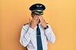 Handsome hispanic man wearing airplane pilot uniform rubbing eyes for fatigue and headache, sleepy and tired expression. vision problem