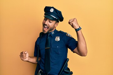 Canvas Print - Handsome hispanic man wearing police uniform dancing happy and cheerful, smiling moving casual and confident listening to music