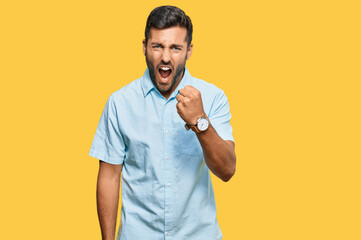 Sticker - Handsome hispanic man wearing casual clothes angry and mad raising fist frustrated and furious while shouting with anger. rage and aggressive concept.