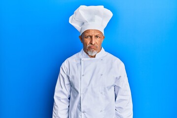 Canvas Print - Middle age grey-haired man wearing professional cook uniform and hat depressed and worry for distress, crying angry and afraid. sad expression.