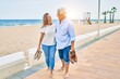 © Krakenimages.com - Middle age hispanic couple smiling happy and hugging walking at the promenade