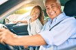© Krakenimages.com - Middle age couple in love sitting inside the car going for a trip smiling happy and cheerful together