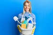 © Krakenimages.com - Beautiful blonde woman wearing cleaner apron holding cleaning products smiling with a happy and cool smile on face. showing teeth.