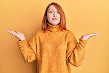 Sticker - Beautiful redhead woman presenting with open palm relaxed with serious expression on face. simple and natural looking at the camera.