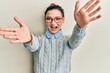 © Krakenimages.com - Young caucasian woman wearing casual clothes and glasses looking at the camera smiling with open arms for hug. cheerful expression embracing happiness.