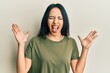 © Krakenimages.com - Young hispanic girl wearing casual t shirt celebrating mad and crazy for success with arms raised and closed eyes screaming excited. winner concept