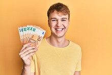 Young Caucasian Man Holding Bunch Of 50 Euro Banknotes Looking Positive And Happy Standing And Smiling With A Confident Smile Showing Teeth
