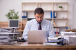 © Elnur - Young businessman employee unhappy with excessive work in the of