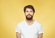 © SHOTPRIME STUDIO - Brunette man on a yellow background in a white t-shirt cropped view
