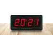 © andy0man - numbers 2021 on digital alarm clock face on wooden table isolated on white background