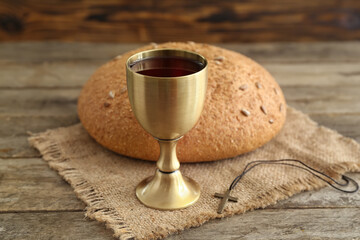 Wall Mural - Chalice of wine with bread and cross on wooden background