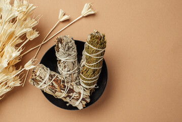 Set of incense for fumigation of premises. Branches of white sage tied in a bunch and dried flowers of Nigella. View from above. Organic holy plant incense from Latin America. Close-up color photo.