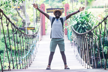 Wall Mural - African man traveler standing on the bridge with smile and happy