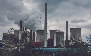 Wall Mural - View of coal power plant against sun with several chimneys and huge fumes