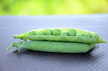 the green ripe peas with beans on the brown background.