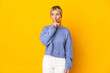 © luismolinero - Young Russian woman isolated on yellow background showing a sign of silence gesture putting finger in mouth