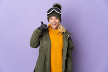 Skier Russian Girl With Snowboarding Glasses Isolated On Purple Background Making Phone Gesture. Call Me Back Sign