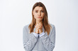 © Cookie Studio - Sad woman pleading and asking for help, begging you, asking please and frowning upset, standing hopeful against white background