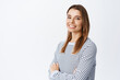© Cookie Studio - Portrait of confident smiling woman, cross arms on chest with determined face and looking at camera, standing against white background