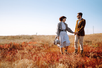 Young couple walks in the park during the spring and hugs. Enjoying time together. The concept of youth, love and lifestyle.