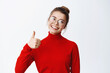 Sounds good, nice work. Smiling female entrepreneur in glasses showing thumb up, approve and like good thing, praise something nice, white background
