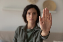 I Said Stop It. Blurred Portrait Of Young Lady Looking At Camera Extending Hand Forward Saying No Enough To Abuse Family Violence Abortion. Focus On Female Palm Close Up Raised In Prohibiting Gesture