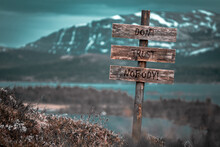 Dont Trust Nobody Text Quote Engraved On Wooden Signpost Outdoors In Landscape Looking Polluted And Apocalyptic.