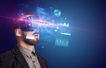 Businessman looking through Virtual Reality glasses with OUTSOURCING inscription, new business concept