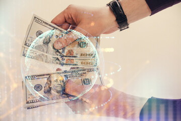 Double exposure of world map drawing hologram and us dollars bills and man hands.