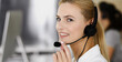 © Iryna - Blonde business woman using headset for communication and consulting people at customer service office. Call center. Group of operators at work