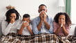 © Prostock-studio - Sick black family blowing runny noses with napkins together
