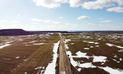 Wall Mural - Top view of a rural dirt road in a field