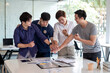 © amnaj - Teamwork of young Asian man putting hands up for new startup in creative office