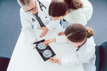 Wall Mural - Team of doctors discussing x-ray on a tablet computer